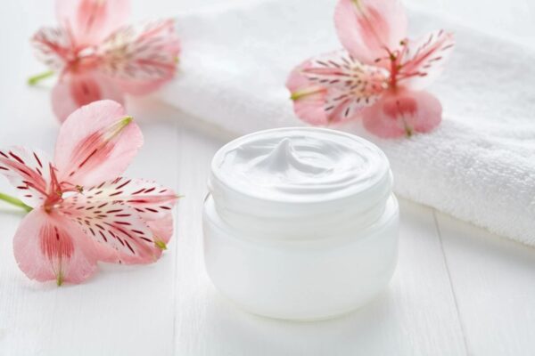 A white jar of cream sitting on top of a table.